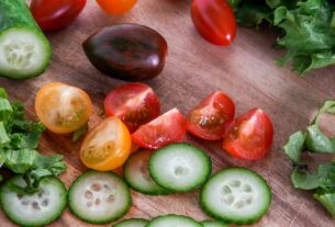 A vibrant assortment of fresh vegetables sliced on a wooden cutting board, perfect for healthy salads.