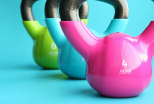 Vibrant colored kettlebells on blue background highlighting fitness and exercise equipment.