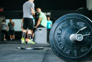 Energetic gym environment showcasing weightlifting equipment and active individuals.