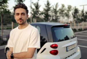 man in white crew neck t-shirt standing beside white car during daytime